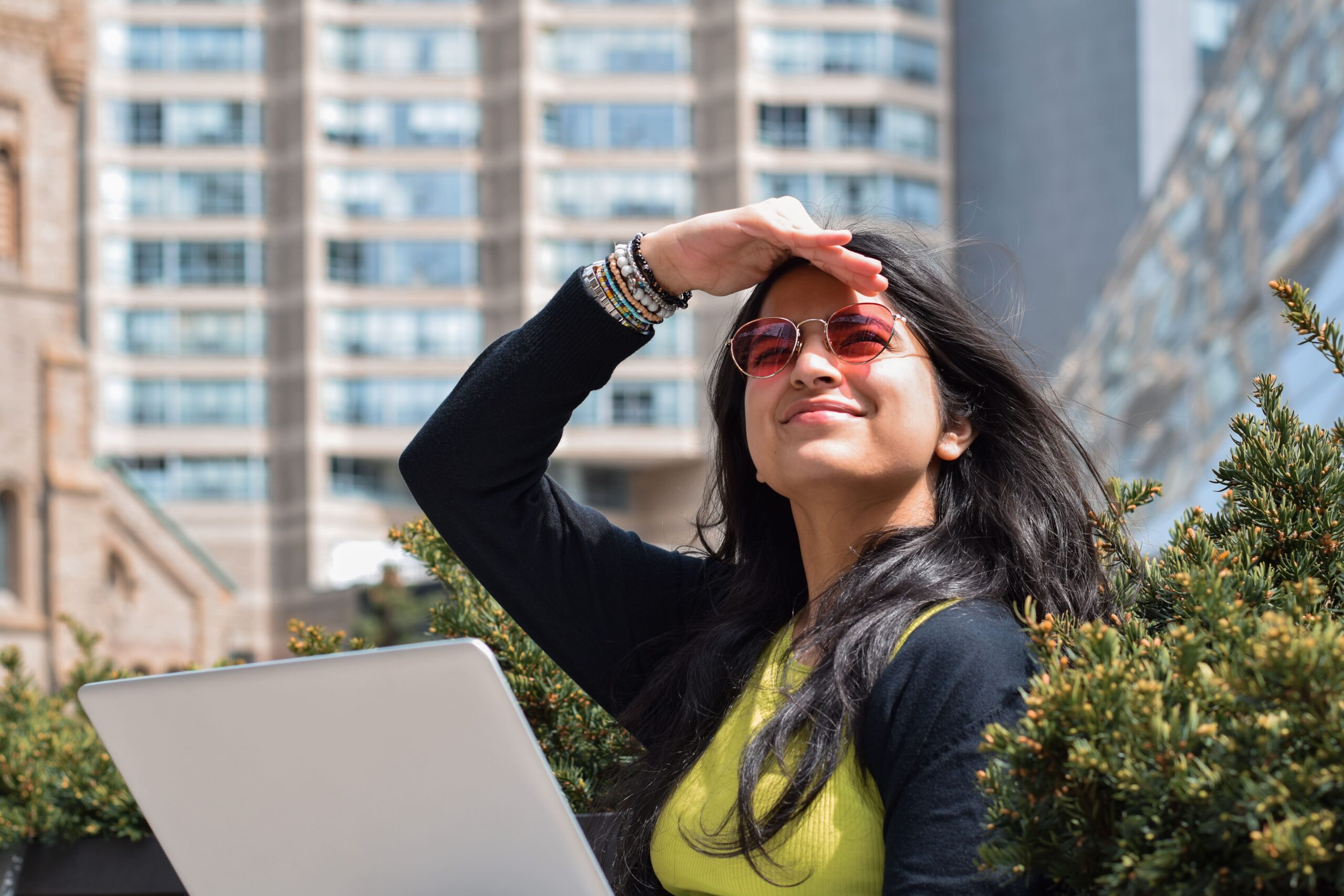mujer con gafas de sol protegiendo sus ojos con la mano